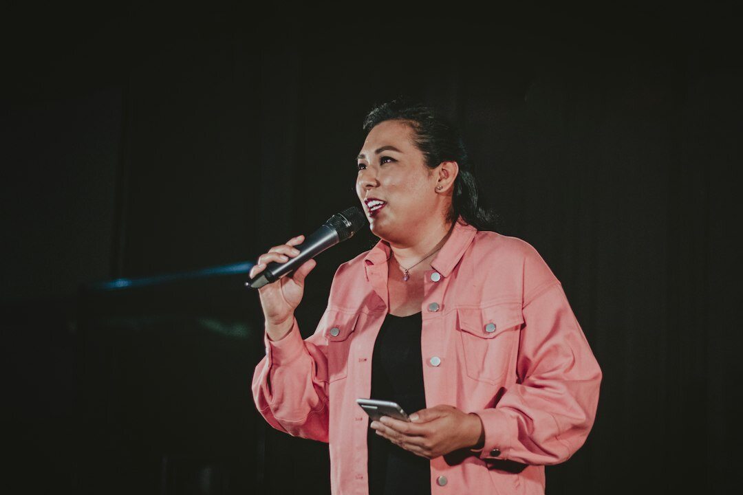 Czech woman confidently giving a public speech on stage